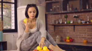 portrait young woman relish healthy fruit diet smiling woman eats fresh apple in loft apartment casual female with happy smile on friendly